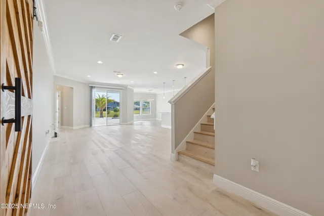 a view of a hallway with wooden floor and entryway