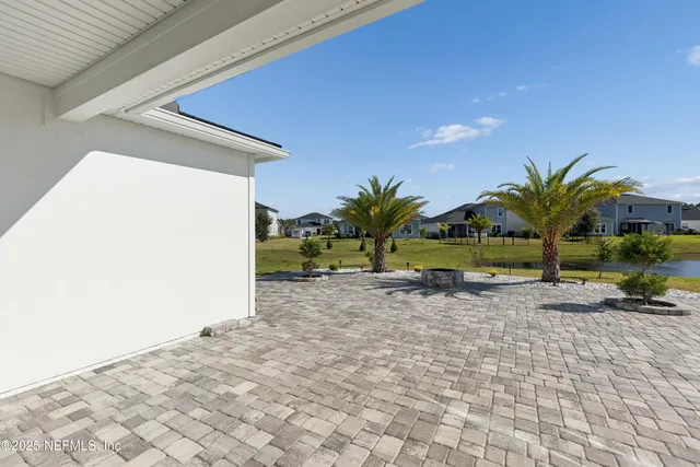 a view of swimming pool with lawn chairs and plants