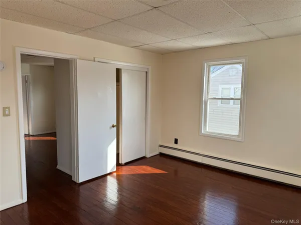 an empty room with wooden floor and closet