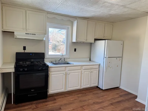 a kitchen with a refrigerator stove and white cabinets
