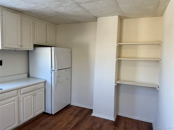 a kitchen with cabinets and a refrigerator
