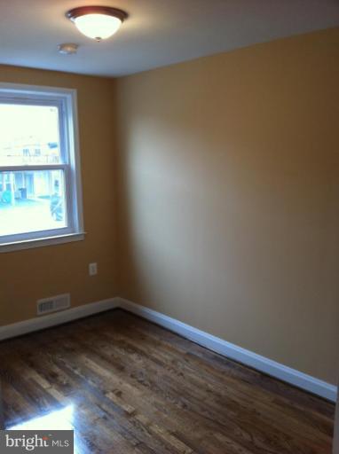 5427 Force Road Baltimore, MD 21206 - Photo 14 of 14 an empty room with wooden floor and windows