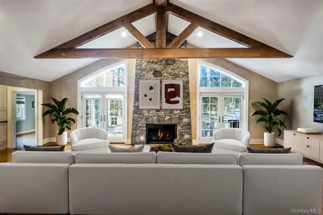 a living room with furniture a fireplace and a large window