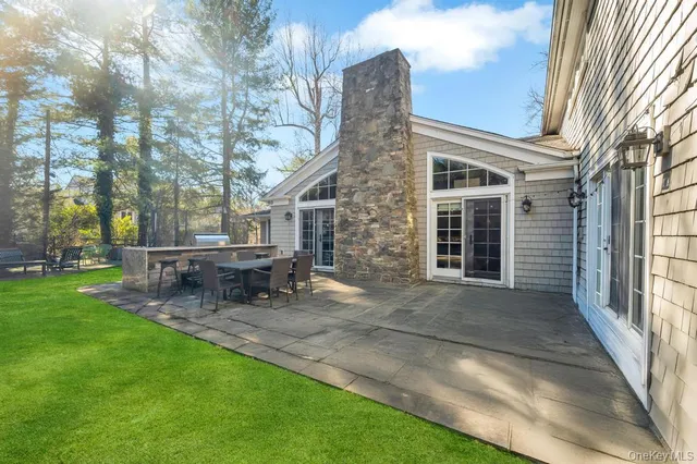 a view of a house with backyard and sitting area