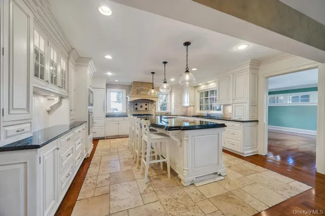 a large kitchen with stainless steel appliances kitchen island granite countertop a sink and cabinets