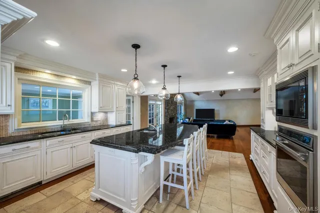 a kitchen with stainless steel appliances kitchen island granite countertop a sink and a stove