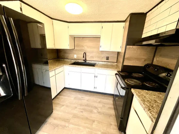 a kitchen with stainless steel appliances a sink stove and cabinets