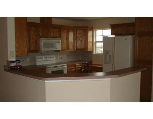 a kitchen with stainless steel appliances a sink a stove a microwave a refrigerator and a microwave