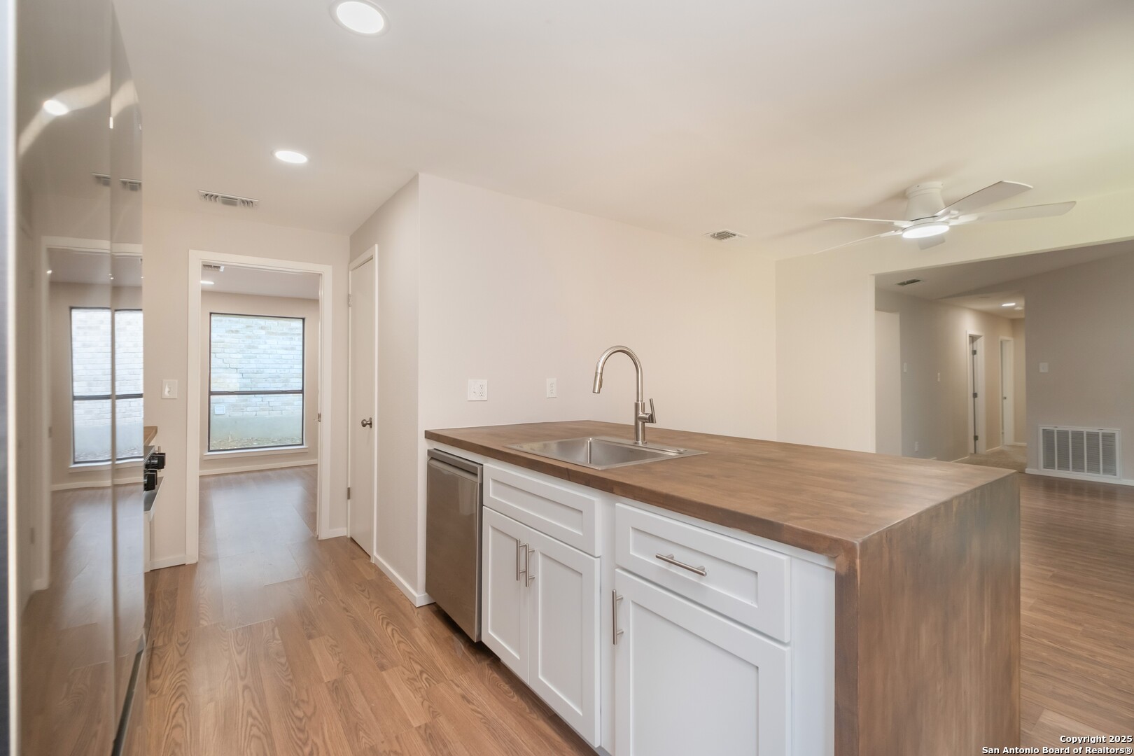 8906 Willmon Way Windcrest, TX 78239 - Photo 11 of 34 a kitchen with a sink cabinets and wooden floor