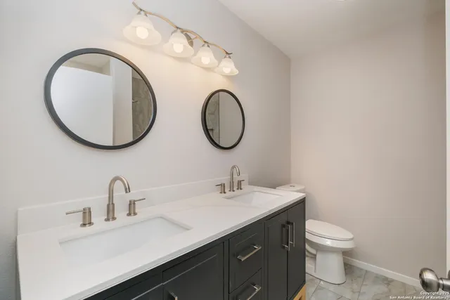 a bathroom with a toilet sink and mirror