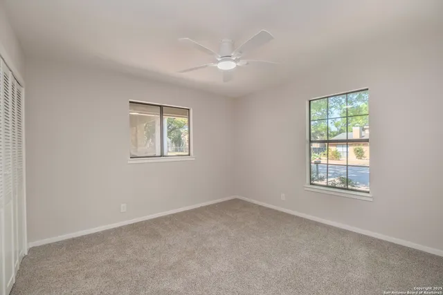 an empty room with windows and closet