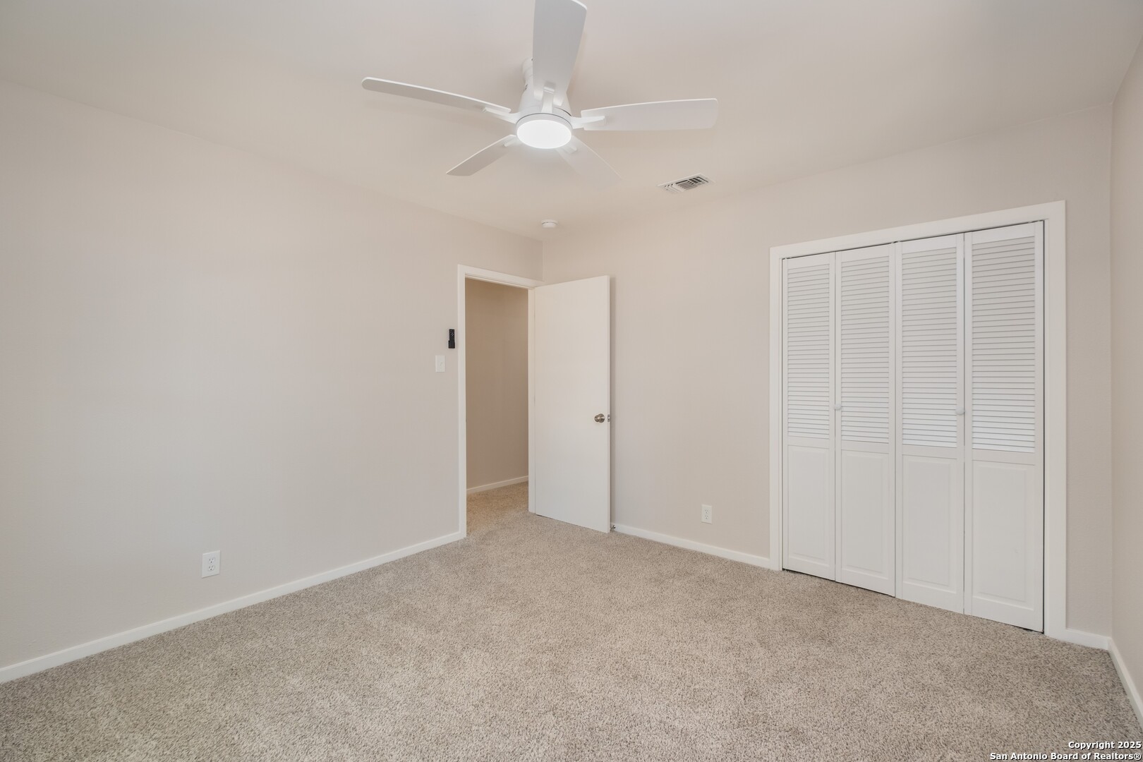 8906 Willmon Way Windcrest, TX 78239 - Photo 26 of 34 an empty room with a ceiling fan and a window
