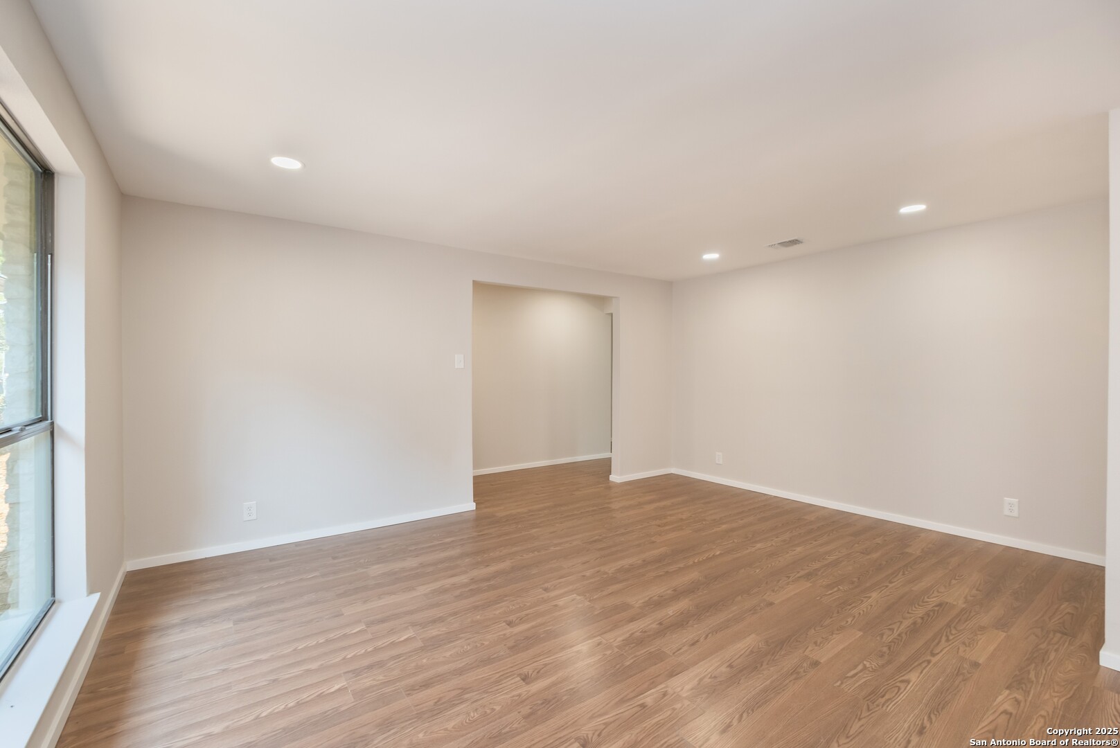 8906 Willmon Way Windcrest, TX 78239 - Photo 5 of 34 a view of an empty room with wooden floor and a window