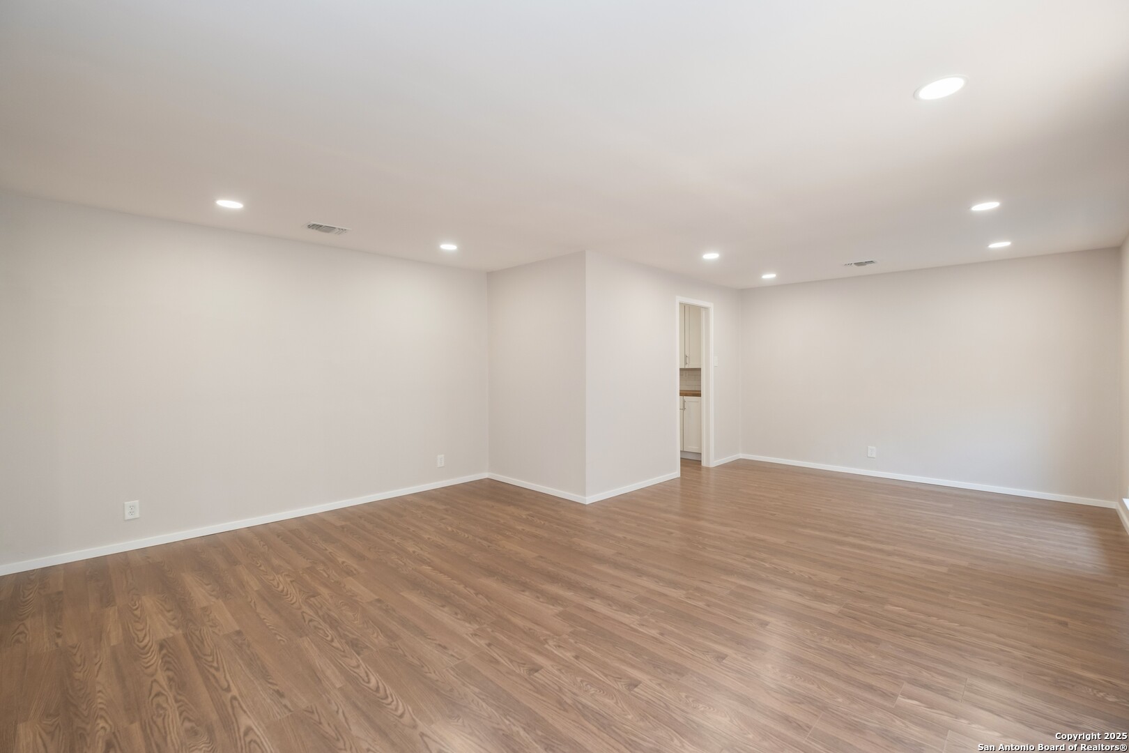 8906 Willmon Way Windcrest, TX 78239 - Photo 6 of 34 an empty room with wooden floor and windows