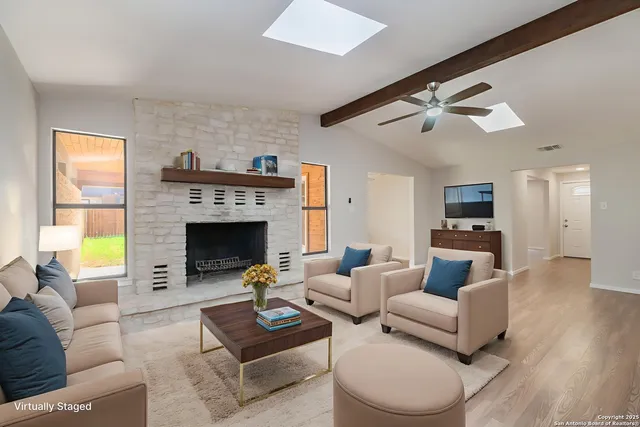 a living room with furniture a fireplace and a flat screen tv