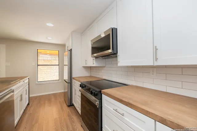 a kitchen that has a sink and a stove top oven