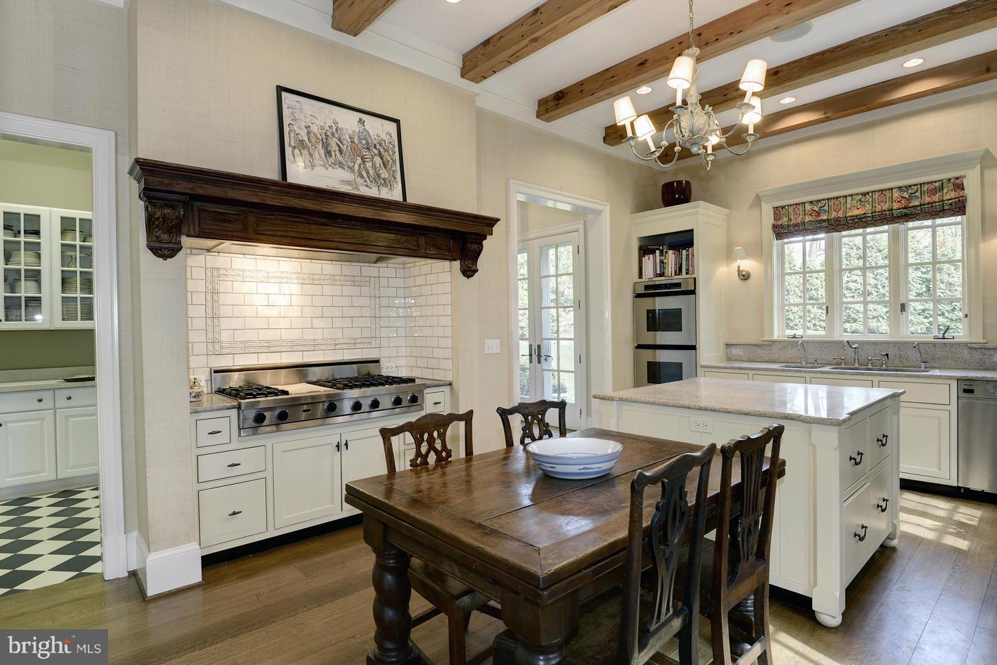 8106 Merrick Road Bethesda, MD 20817 - Photo 11 of 27 a kitchen with stainless steel appliances granite countertop a stove a kitchen island a dining table and chairs