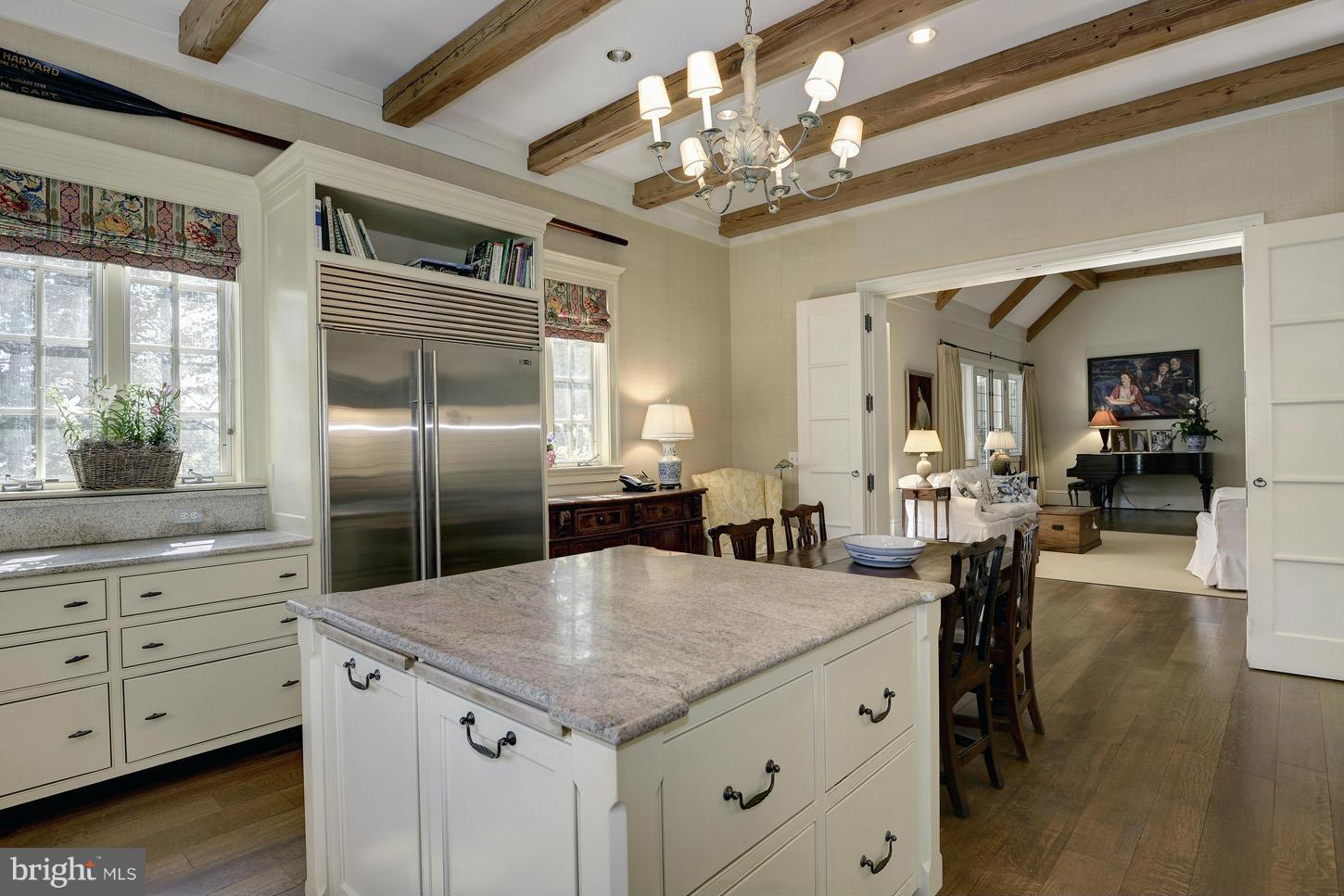 8106 Merrick Road Bethesda, MD 20817 - Photo 13 of 27 a kitchen with granite countertop a center island a chandelier stainless steel appliances and cabinets