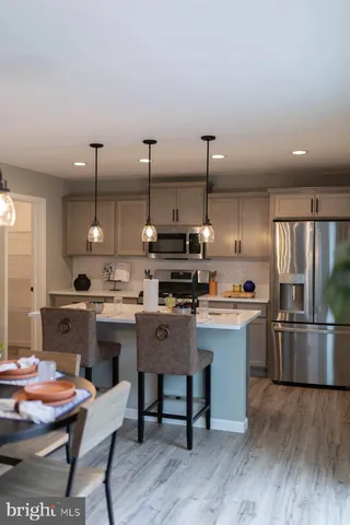 a kitchen with a table chairs stove and wooden floor