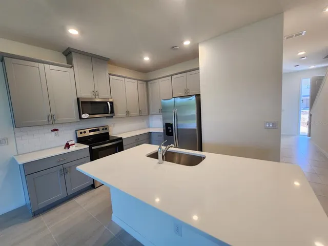 a kitchen with cabinets appliances and a sink