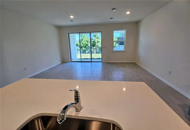 an empty room with kitchen view and appliances