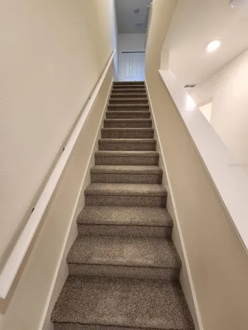 a view of hallway with stairs and wooden floor