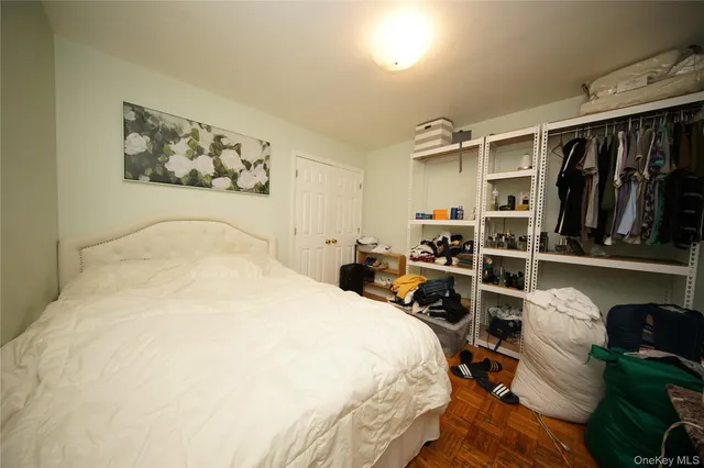 a bedroom with bed and wooden floor