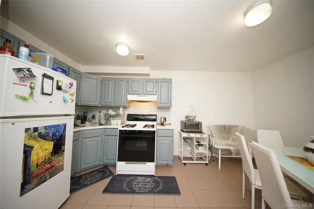 a kitchen with stainless steel appliances granite countertop a stove top oven a sink a dining table and chairs with wooden floor