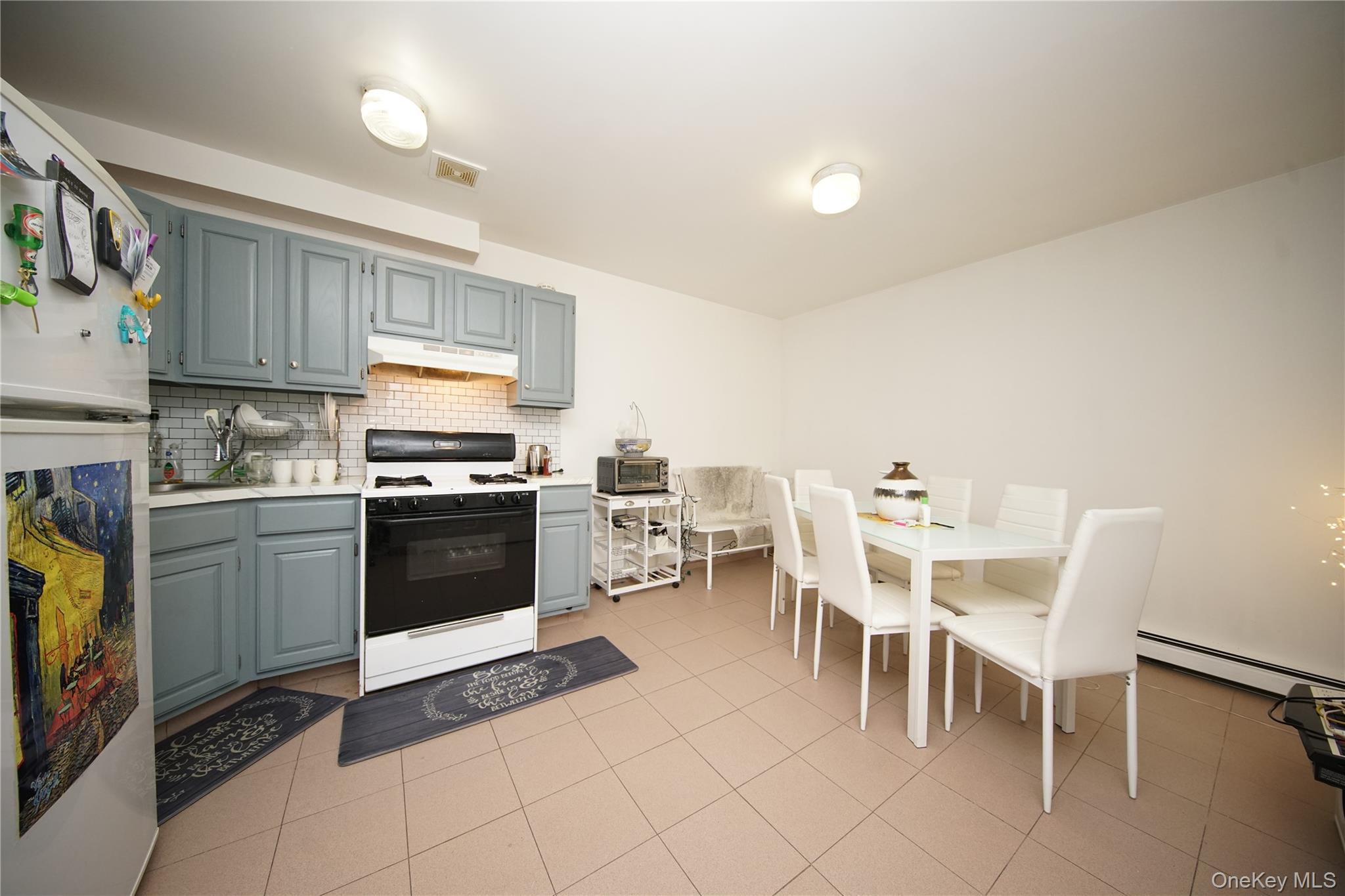 109-12 Westside Avenue Queens, NY 11368 - Photo 6 of 16 a kitchen with a table chairs microwave and cabinets