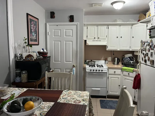a kitchen with stainless steel appliances a stove refrigerator and cabinets
