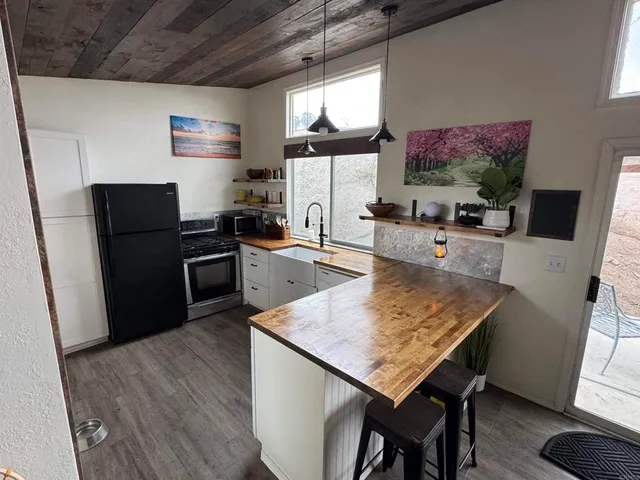 a kitchen with stainless steel appliances wooden floor dining table and chairs