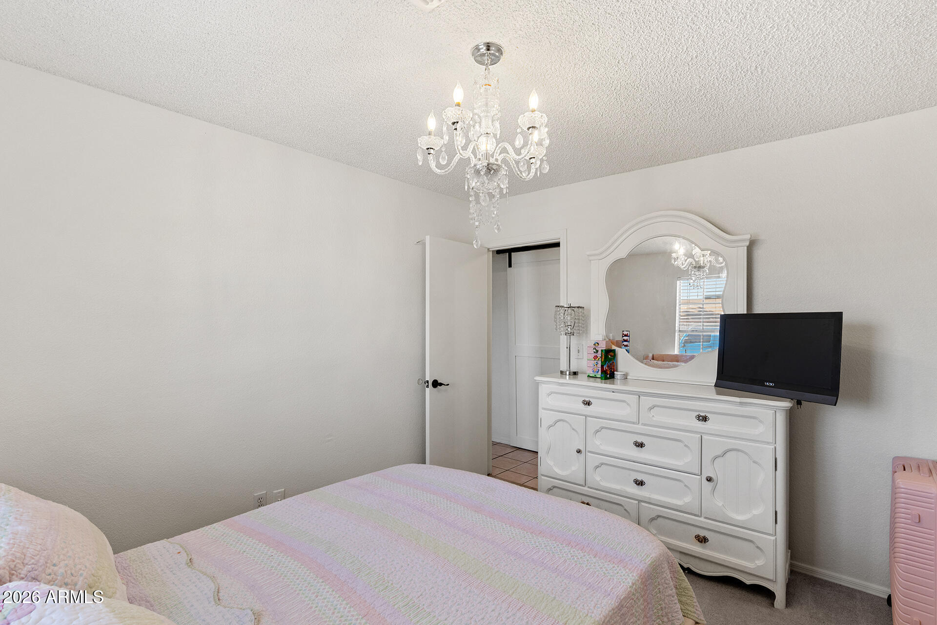 9002 West Coronado Road Phoenix, AZ 85037 - Photo 39 of 54 a bedroom with a bed and a chandelier