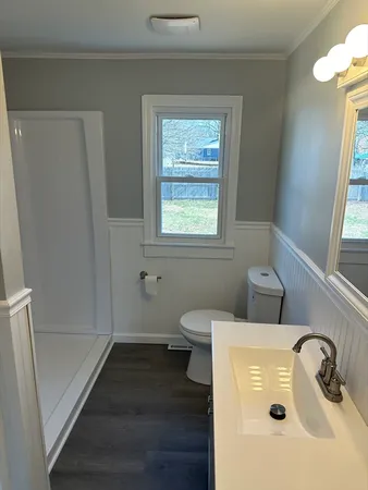 a bathroom with a sink a window and a toilet