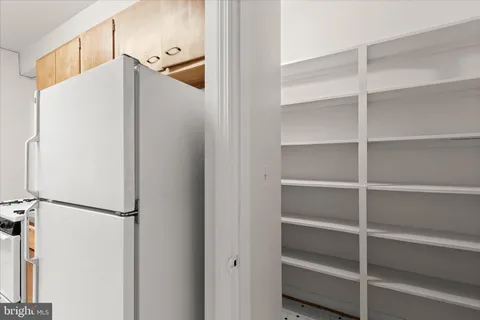 a white refrigerator freezer and a wooden floor