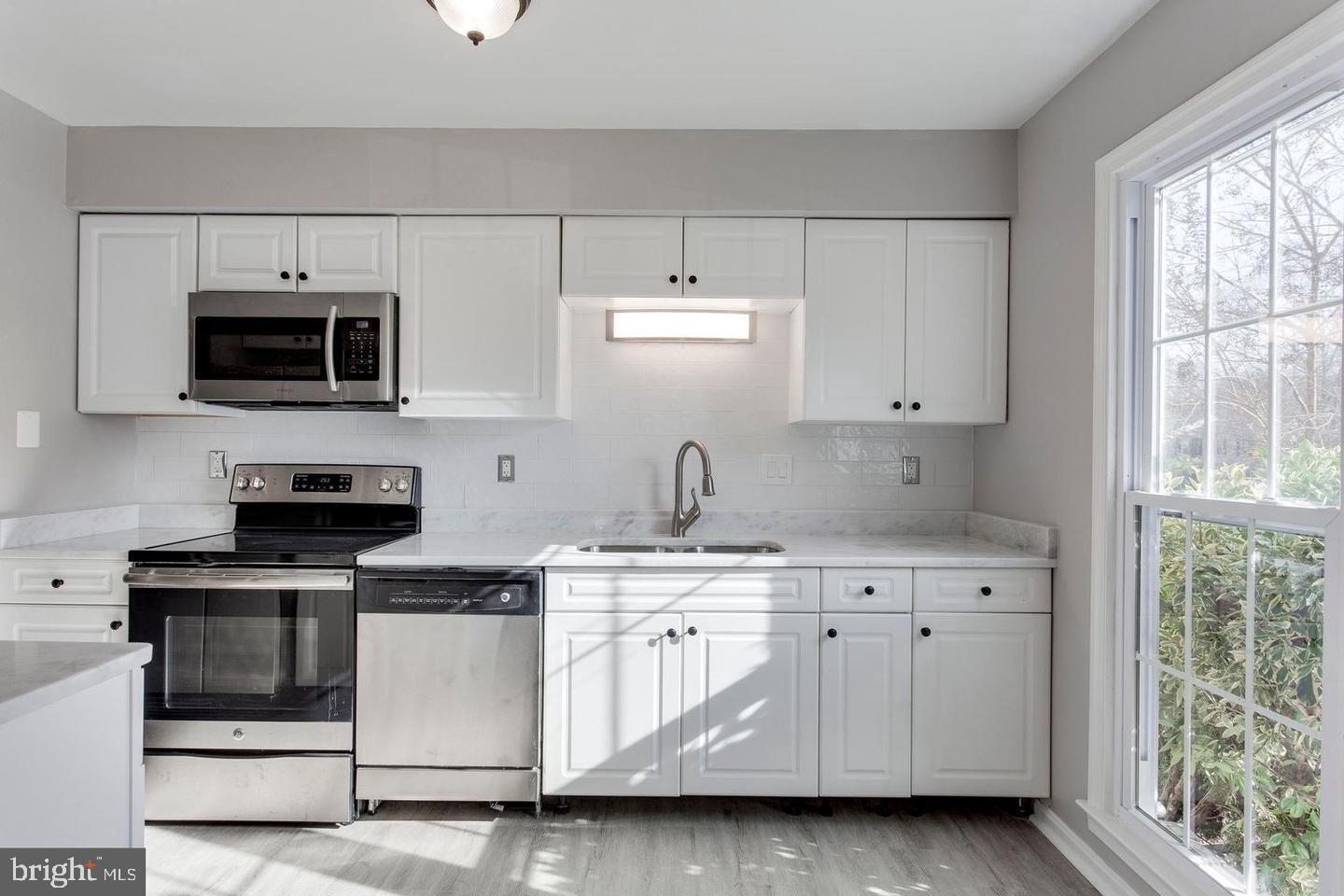 304 Crescendo Way Silver Spring, MD 20901 - Photo 11 of 29 a kitchen with white cabinets and white appliances