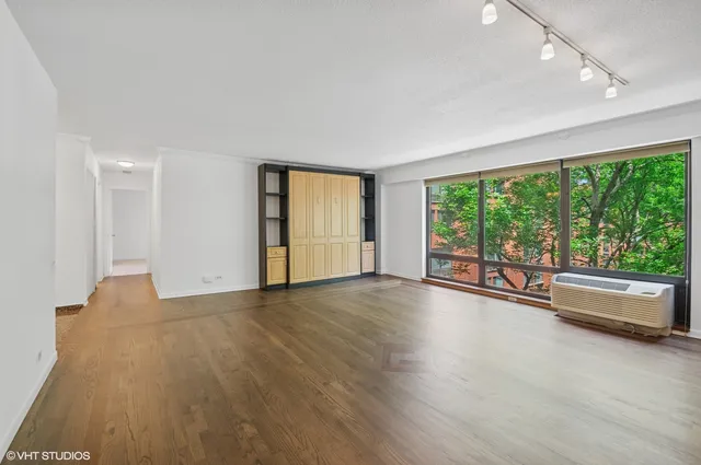 a view of empty room with wooden floor and windows