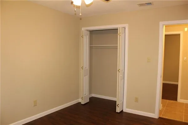 an empty room with wooden floor and closet