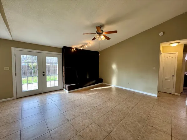 a view of an empty room with a fireplace and a fan