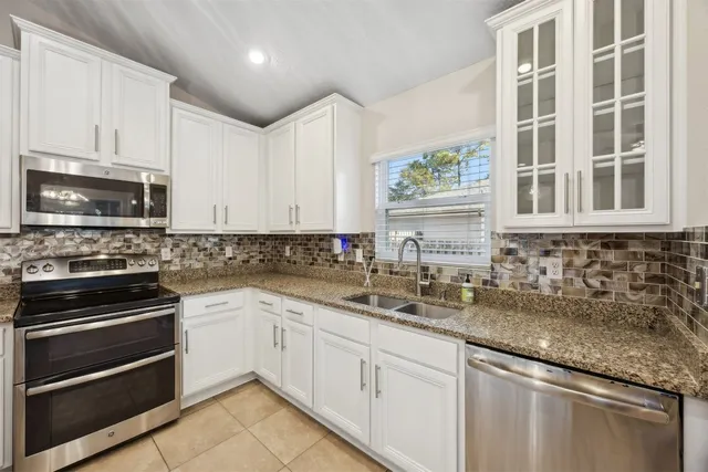 a kitchen with stainless steel appliances granite countertop a sink and cabinets