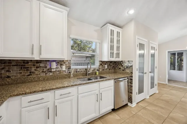 a kitchen with stainless steel appliances granite countertop a stove oven and a refrigerator with white cabinets