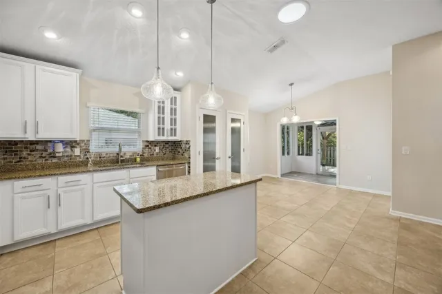 a kitchen with granite countertop white cabinets and stainless steel appliances