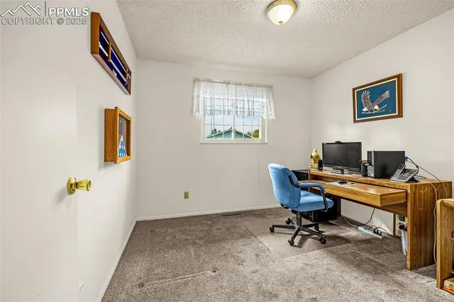 a view of a workspace with furniture and a window