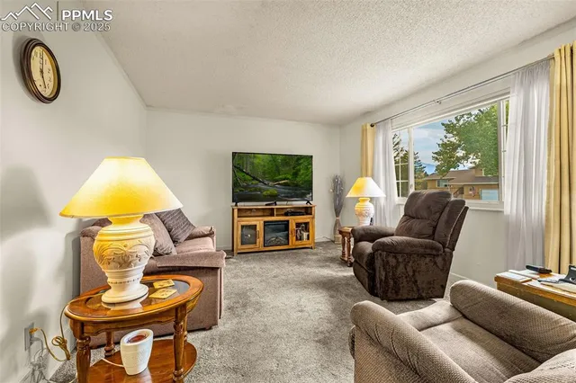 a living room with furniture a window and a flat screen tv