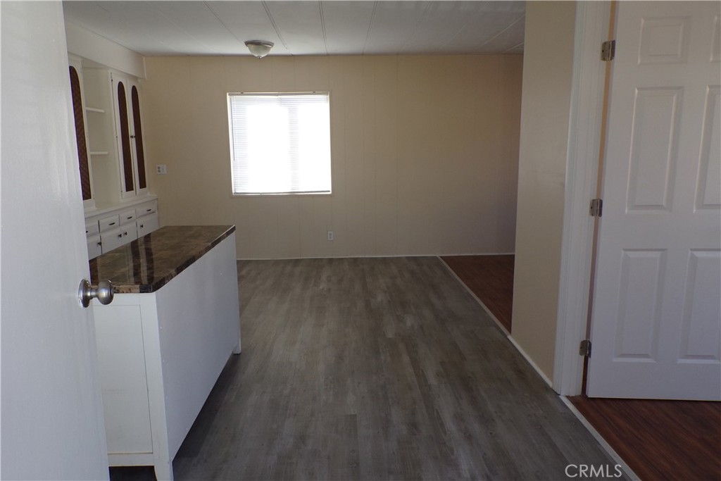12710 3rd Street, Unit 91 Yucaipa, CA 92399 - Photo 3 of 21 wooden floor in an empty room with a window