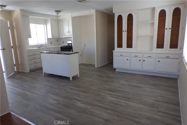 a kitchen with cabinets and wooden floor
