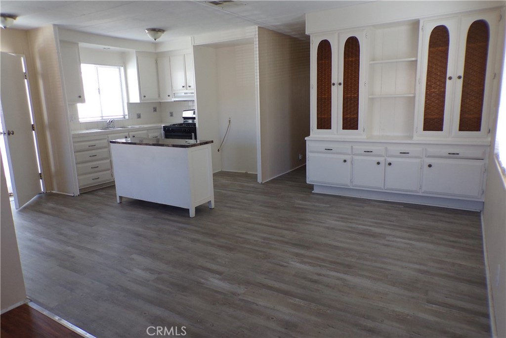 12710 3rd Street, Unit 91 Yucaipa, CA 92399 - Photo 4 of 21 a kitchen with cabinets and wooden floor
