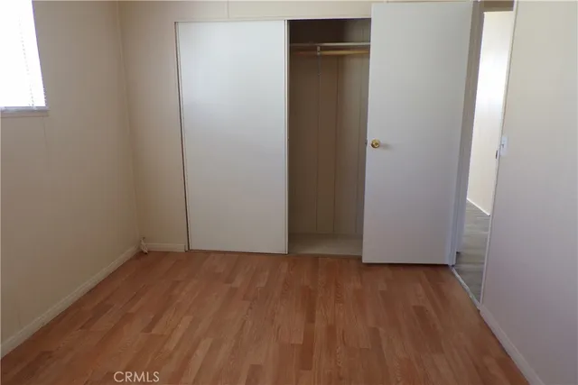 an empty room with wooden floor and closet