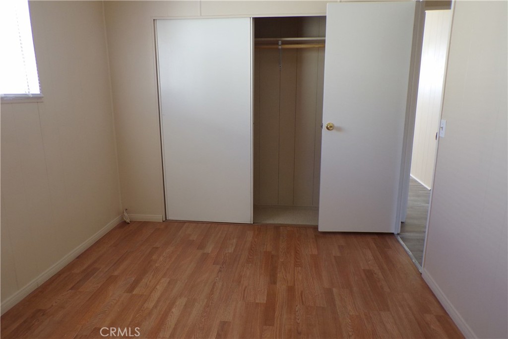 12710 3rd Street, Unit 91 Yucaipa, CA 92399 - Photo 8 of 21 an empty room with wooden floor and closet