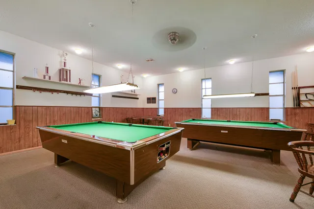 a room with pool table and wooden floor
