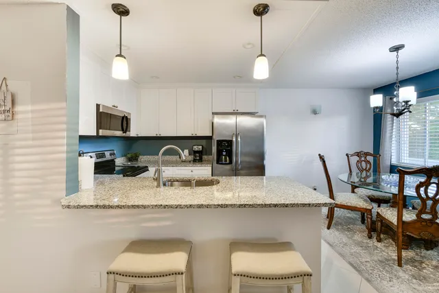 a kitchen with stainless steel appliances granite countertop a sink a stove and a refrigerator